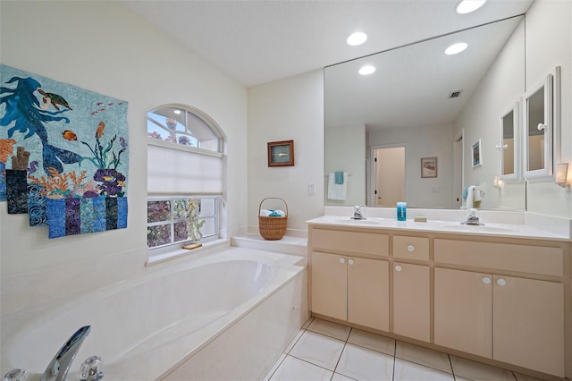 bathroom with vanity, a tub to relax in, a textured ceiling, and tile patterned flooring