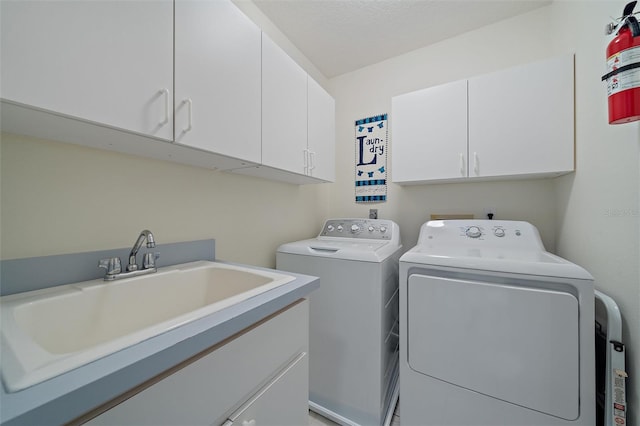 washroom with sink, washer and clothes dryer, and cabinets