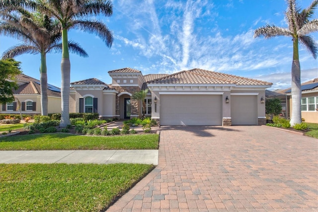 mediterranean / spanish home featuring a garage and a front yard