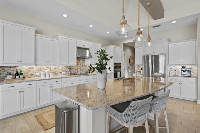 kitchen with white cabinetry, pendant lighting, an island with sink, and appliances with stainless steel finishes