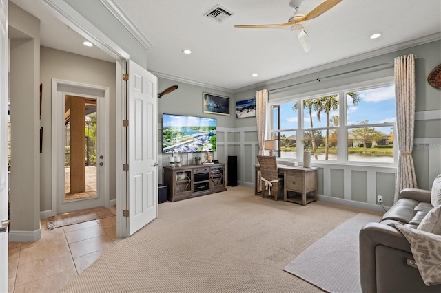 carpeted living room with crown molding and ceiling fan