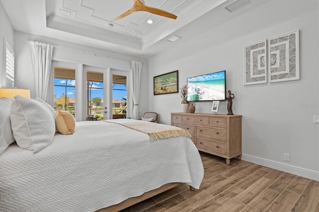 bedroom with crown molding, access to exterior, ceiling fan, and a tray ceiling