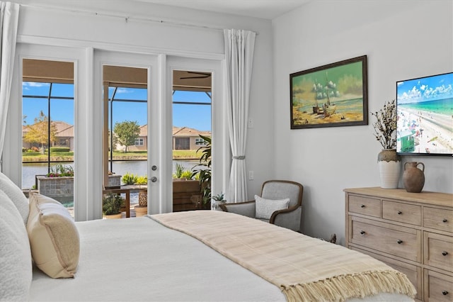 bedroom featuring a water view, access to exterior, and multiple windows