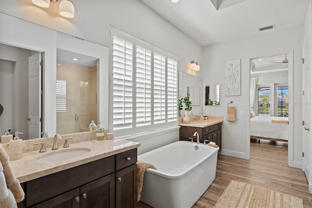 bathroom featuring hardwood / wood-style flooring, vanity, and shower with separate bathtub