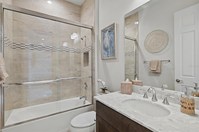 full bathroom featuring enclosed tub / shower combo, vanity, and toilet