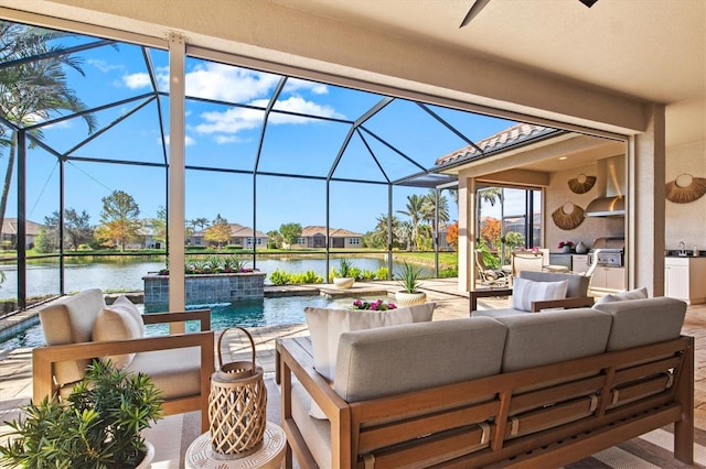 view of patio featuring an outdoor kitchen, a water view, glass enclosure, outdoor lounge area, and ceiling fan