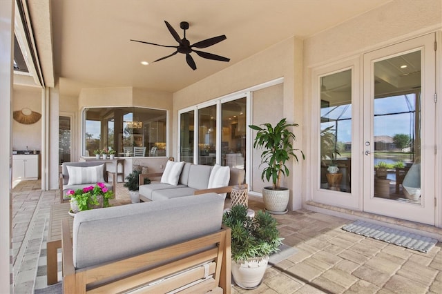 view of patio with an outdoor living space, ceiling fan, and french doors