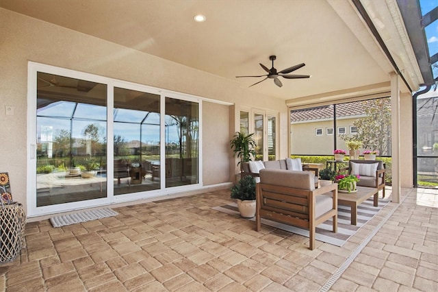 view of patio featuring an outdoor hangout area, ceiling fan, and glass enclosure