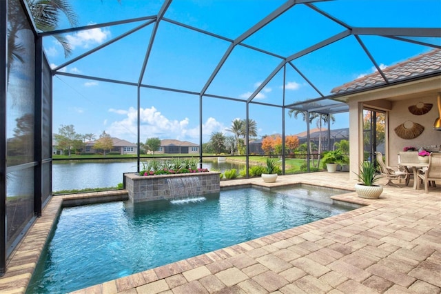 view of pool with pool water feature, a water view, a patio area, and glass enclosure