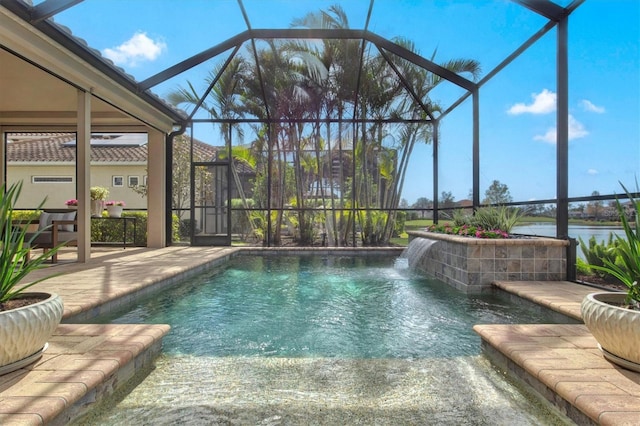 view of pool with a patio, a water view, pool water feature, and glass enclosure