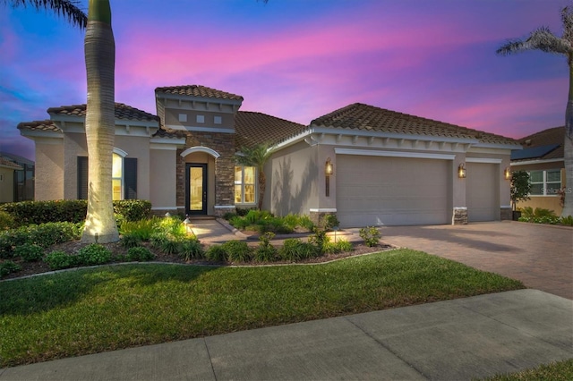 mediterranean / spanish-style house featuring a yard and a garage