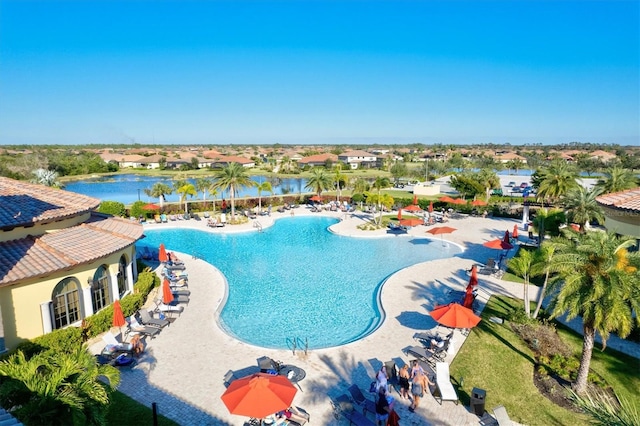 view of pool featuring a water view and a patio