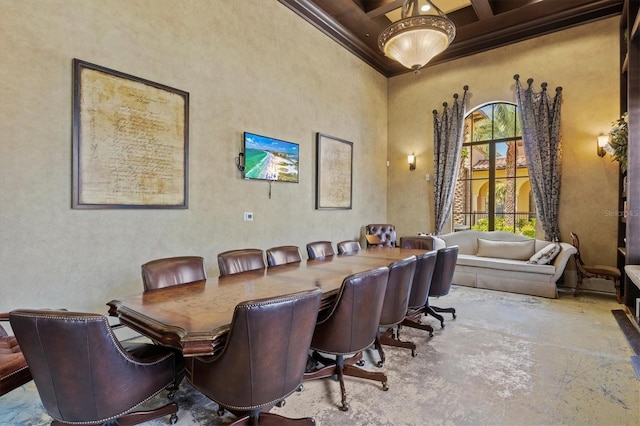 dining room featuring coffered ceiling, crown molding, beamed ceiling, and a towering ceiling