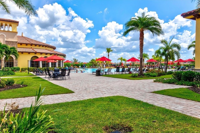 view of community with a pool, a yard, and a patio area