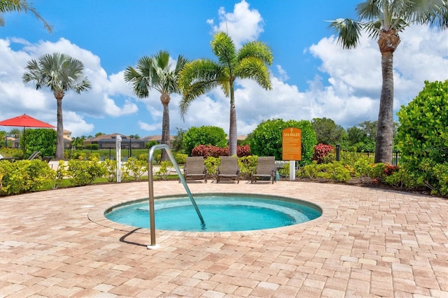 view of swimming pool featuring a hot tub