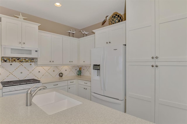 kitchen featuring white cabinets, white appliances, and tasteful backsplash