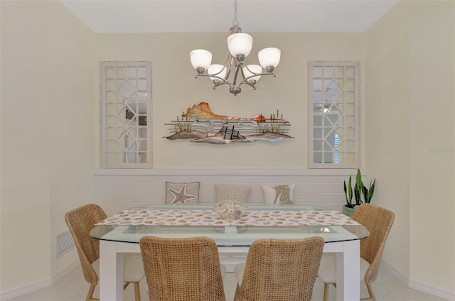 tiled dining room with an inviting chandelier