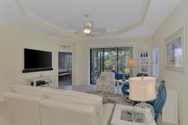 tiled living room featuring ceiling fan, crown molding, and a tray ceiling