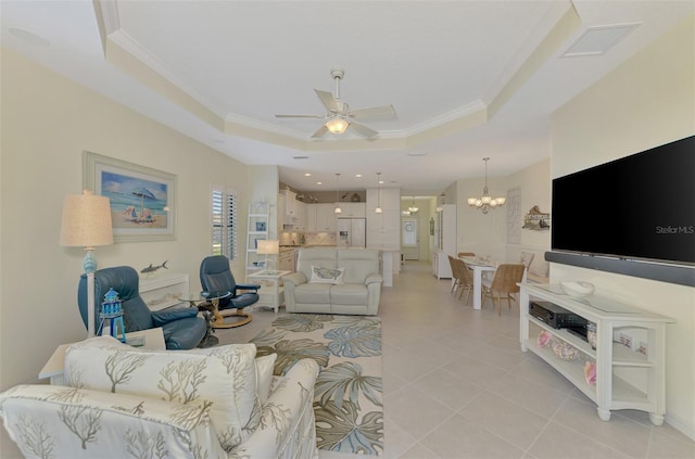 tiled living room featuring ornamental molding, ceiling fan with notable chandelier, and a raised ceiling