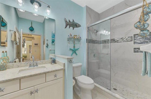 bathroom featuring vanity, toilet, and walk in shower