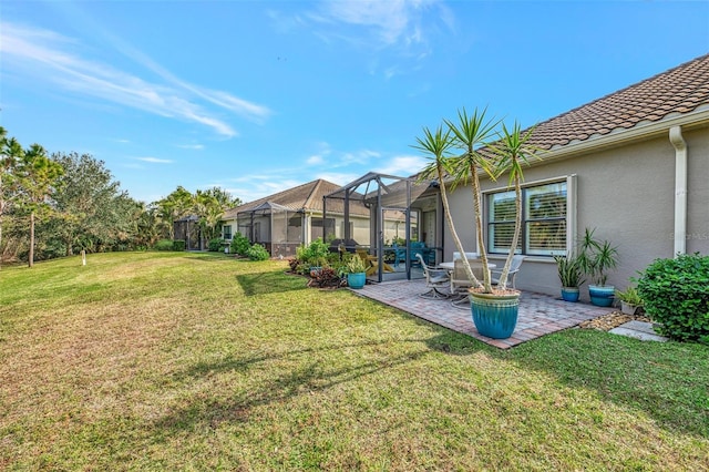 view of yard with glass enclosure and a patio area