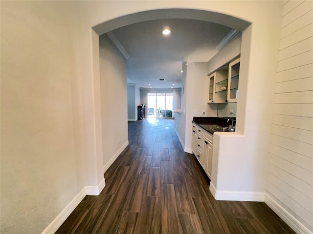 corridor featuring sink, ornamental molding, and dark hardwood / wood-style flooring