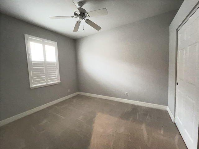 carpeted spare room with ceiling fan