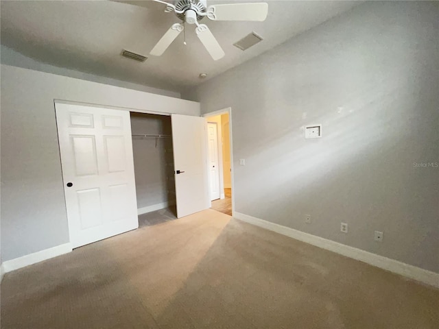 unfurnished bedroom featuring ceiling fan, a closet, and light carpet