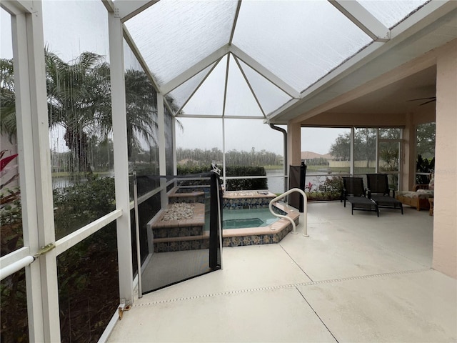 sunroom featuring a water view and a jacuzzi