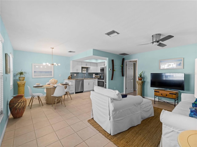 living room featuring light tile patterned flooring and ceiling fan with notable chandelier