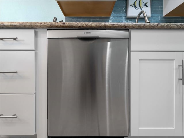 1423 Avenida Del Circo Unit 1C, Venice, FL 34285 - kitchen view of dishwasher, white cabinetry, and dark stone countertops