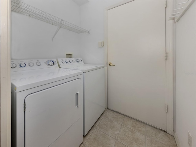 laundry area with washing machine and dryer and light tile patterned floors