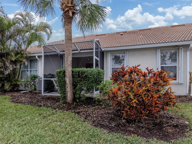 view of home's exterior with a lanai and a yard