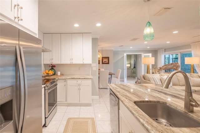 kitchen featuring sink, stainless steel appliances, light stone countertops, decorative backsplash, and white cabinets