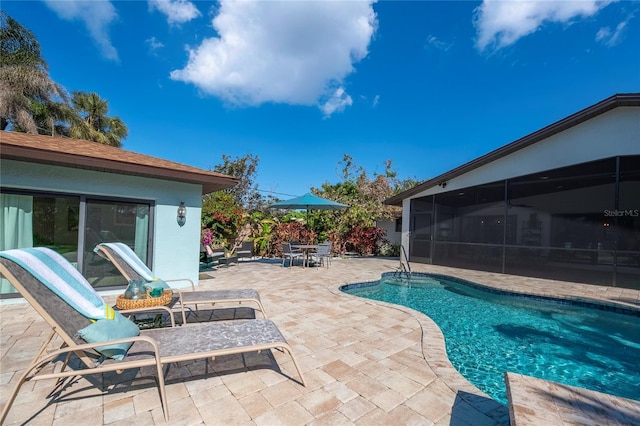 view of swimming pool with a sunroom and a patio