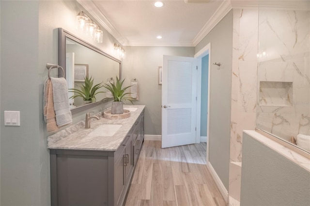 bathroom with hardwood / wood-style flooring, ornamental molding, and vanity