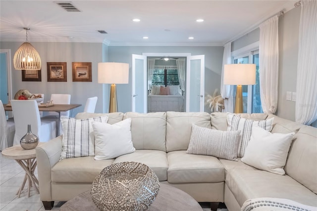 living room with light tile patterned floors, a notable chandelier, and ornamental molding