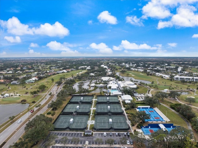 drone / aerial view with a water view and golf course view