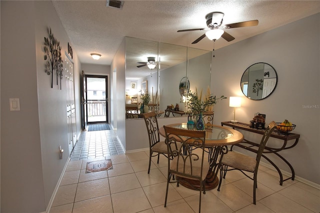 dining area featuring light tile patterned flooring, ceiling fan, and a textured ceiling