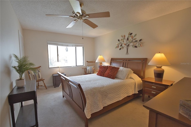 bedroom featuring light carpet, a textured ceiling, and ceiling fan