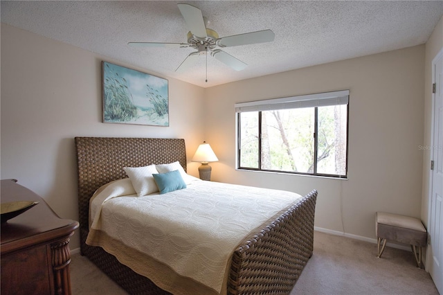 carpeted bedroom with ceiling fan and a textured ceiling