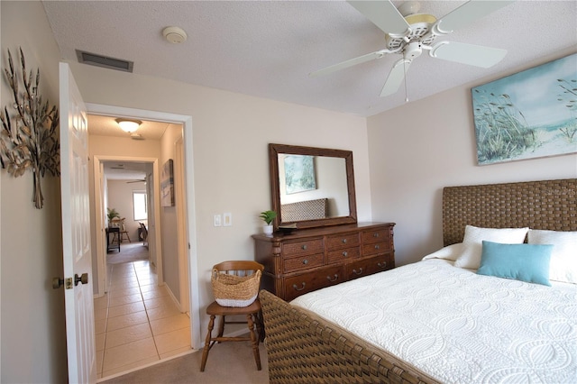 tiled bedroom featuring ceiling fan and a textured ceiling