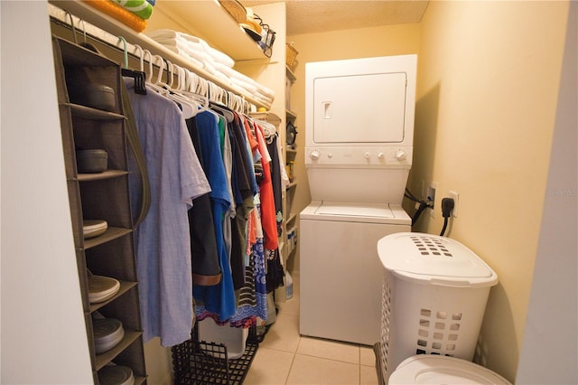 laundry area featuring stacked washer and dryer and light tile patterned floors