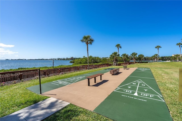 surrounding community with a water view and a yard