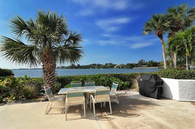 view of patio with area for grilling and a water view