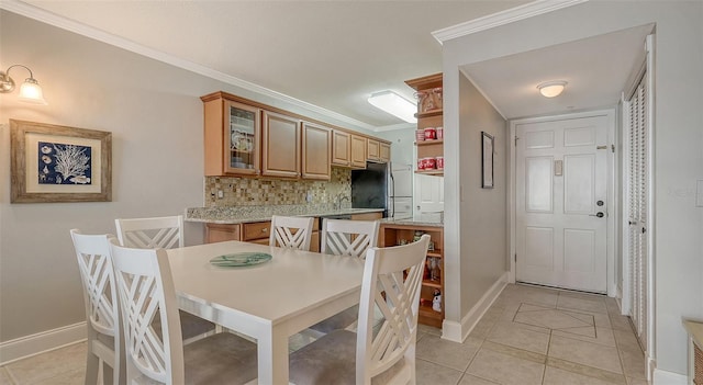 dining room featuring crown molding and light tile patterned flooring