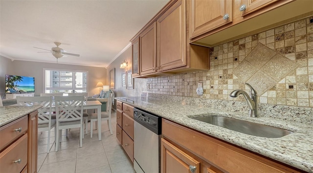 kitchen featuring sink, crown molding, light tile patterned floors, dishwasher, and light stone counters