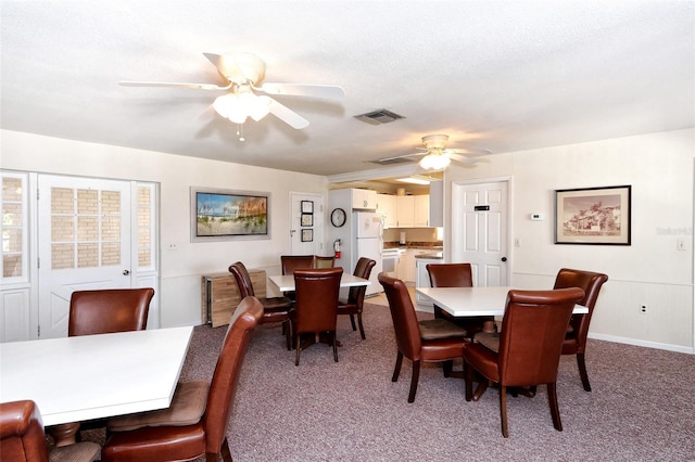 dining space with ceiling fan, carpet flooring, and a textured ceiling