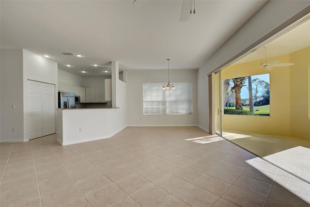 unfurnished living room featuring light tile patterned flooring and ceiling fan with notable chandelier