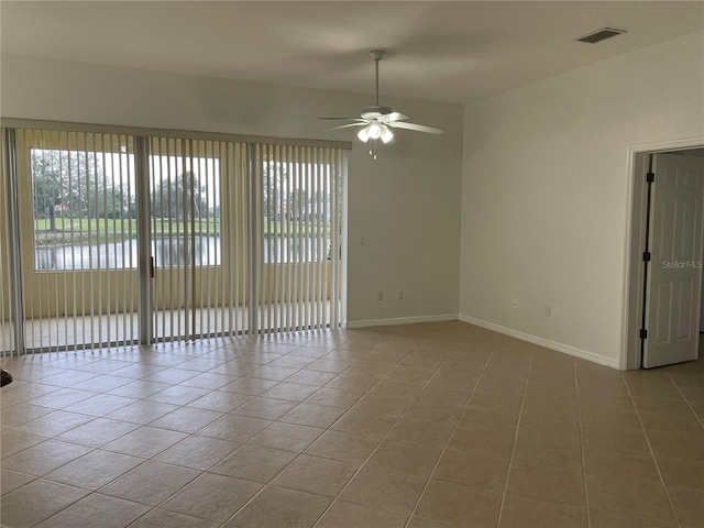 tiled empty room featuring ceiling fan and a healthy amount of sunlight